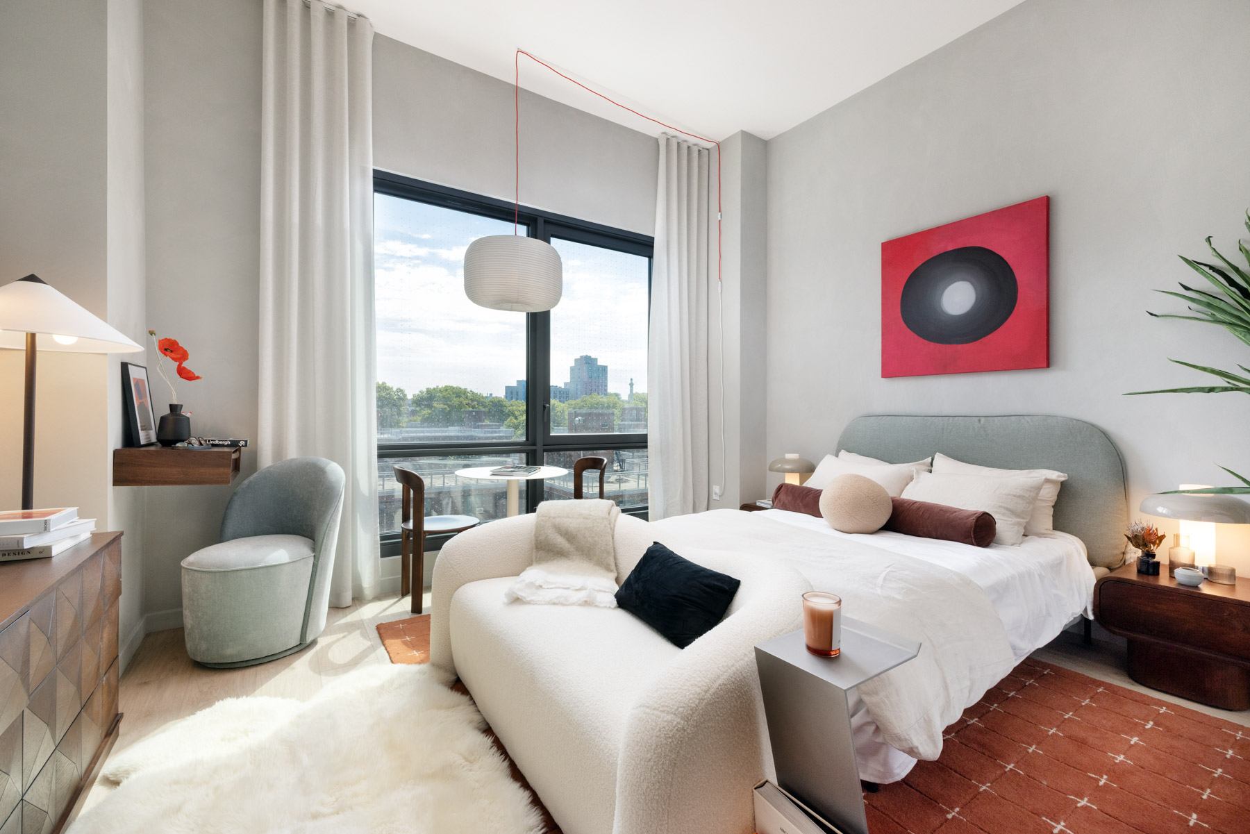 Studio detail showing bed, coffee table, media cabinet and seating by large window