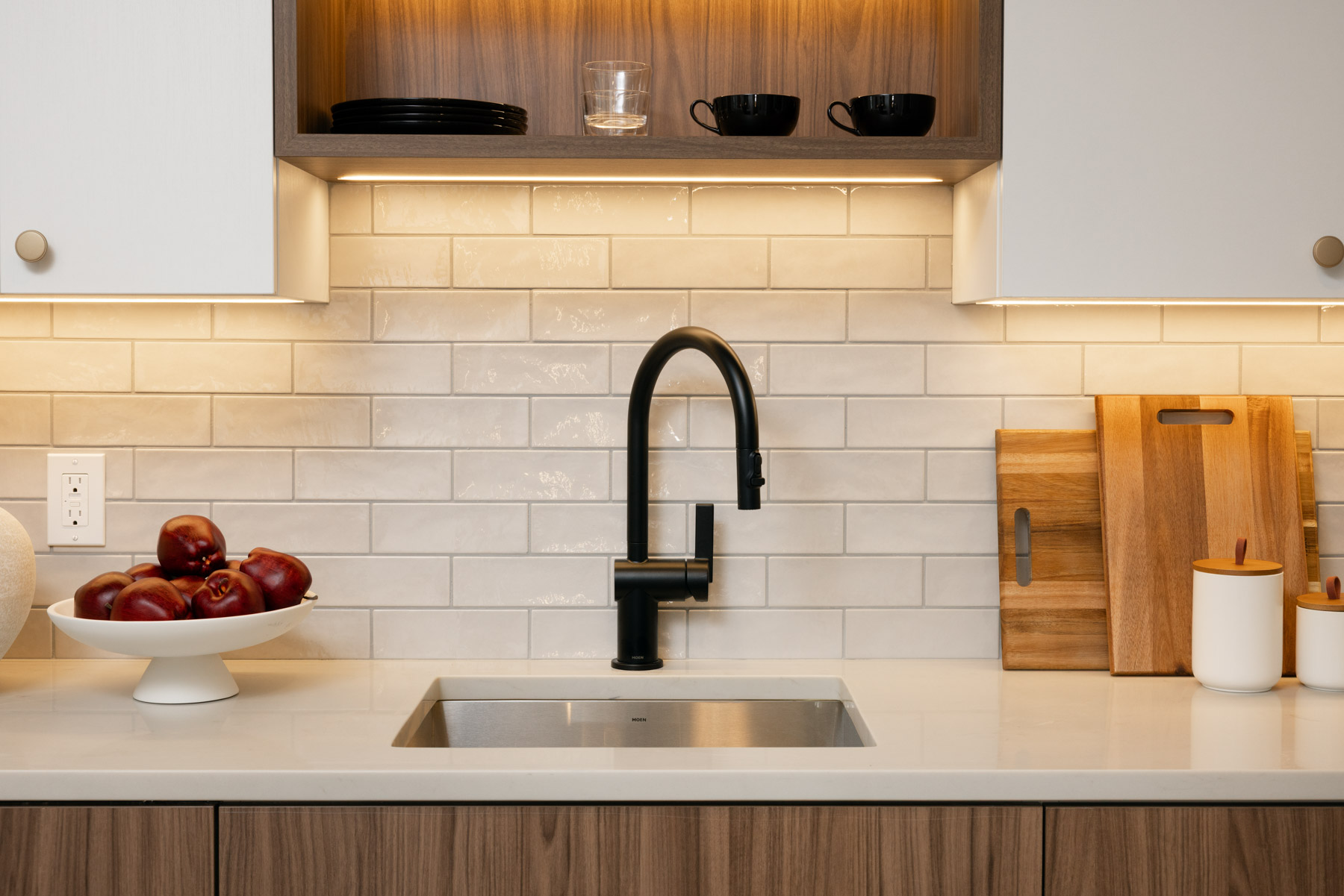 Kitchen detail showing sink with dark fixtures, White Upper/Dark Walnut cabinets