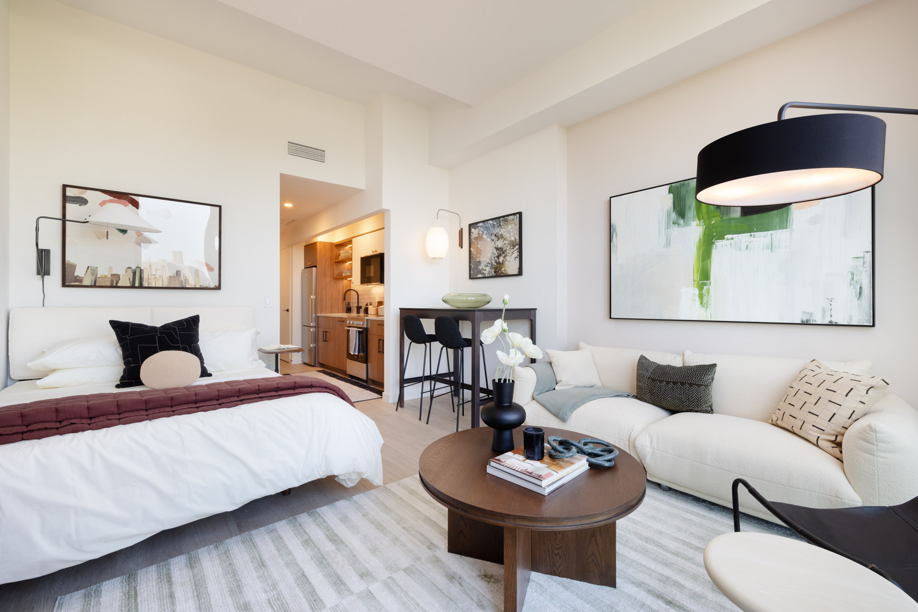 Studio bedroom with seatings areas, couch, coffee table with kitchen in view