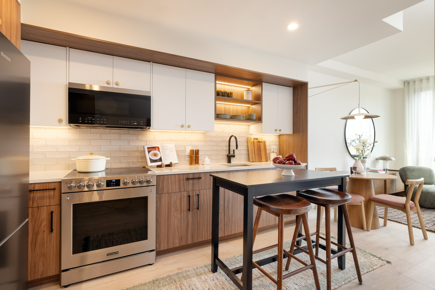Kitchen detail showing seating with bar stools, White Upper/Dark Walnut cabinets, London Grey Quartz Countertops and Stainless Steel Appliances