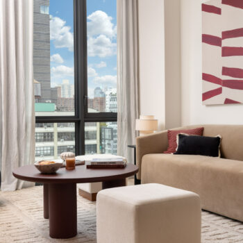 Bright living room with couch, coffee table and large window