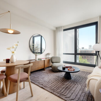 Bright living room with seating, large mirror on wall and large windows