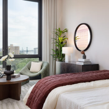 Studio detail showing bed, coffee table, media cabinet and seating by large window